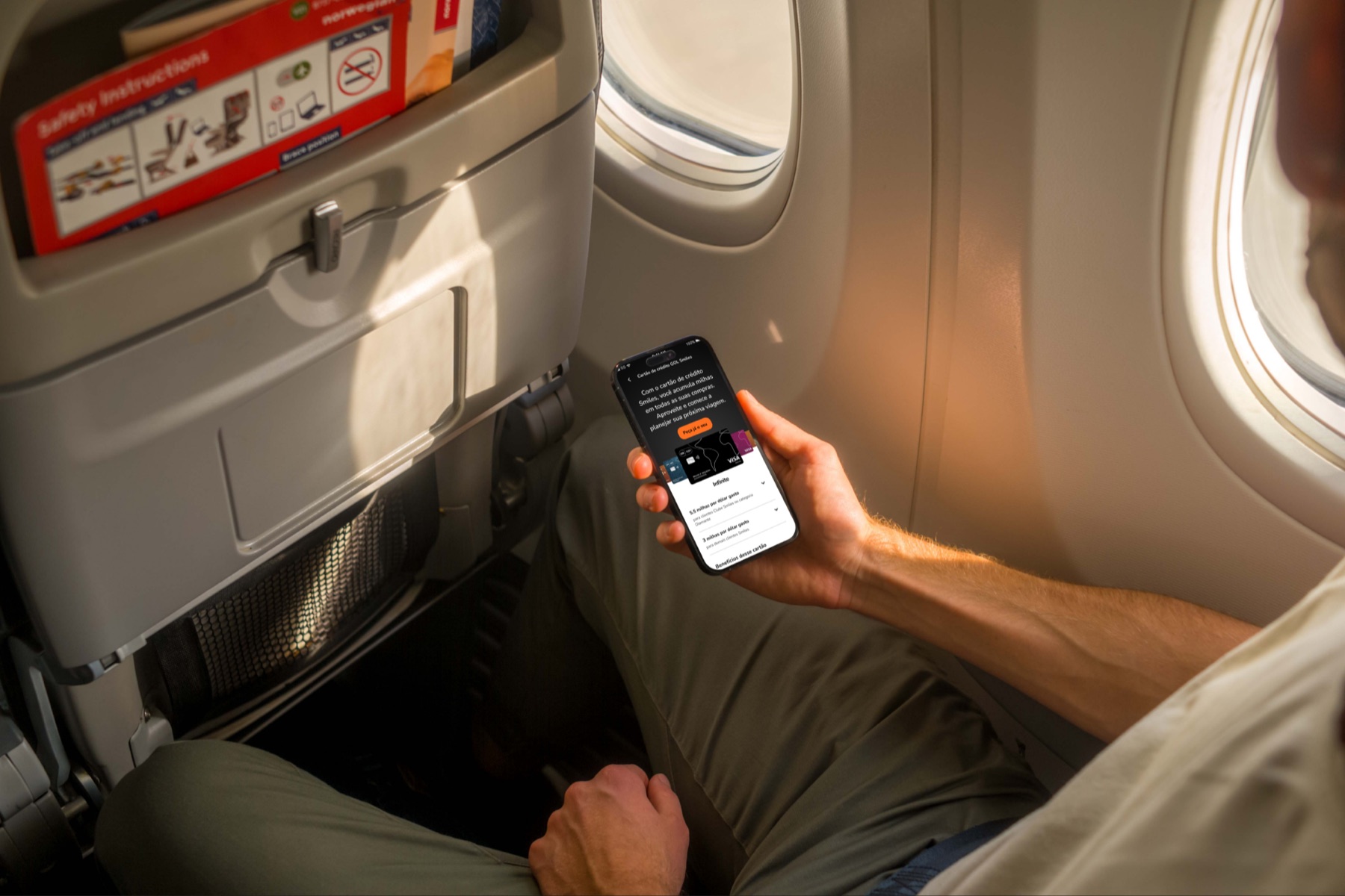 App Smiles aberto na página do cartão GOL Smiles Infinite, dentro de um avião